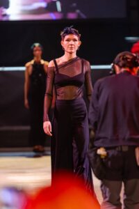 Una modella incarna l'eleganza moderna con un taglio corto espressivo, sfilando con fiducia sul palco del Kadus a Bologna