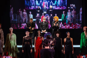 L'Apoteosi dello Stile, Saluti Finali al Kadus Event di Bologna Il team creativo e i modelli ricevono un caloroso applauso al termine dello spettacolare evento di moda Kadus a Bologna, con le loro creazioni proiettate come opere d'arte viventi sullo sfondo del palco.