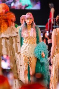 Un incantevole gioco di colori pastello nei capelli si abbina alla vivacità dell'abito, creando una visione da sogno per la sfilata Kadus